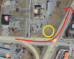 Aerial map showing a yellow circle marking a spot along a red route near Rue Principale, with Tim Hortons and Farnham fire station nearby.